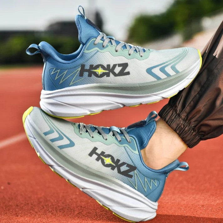 Scarpe da corsa HOKZ su pista atletica, design moderno blu e grigio, suola ammortizzata, ideali per jogging e sport all'aperto.