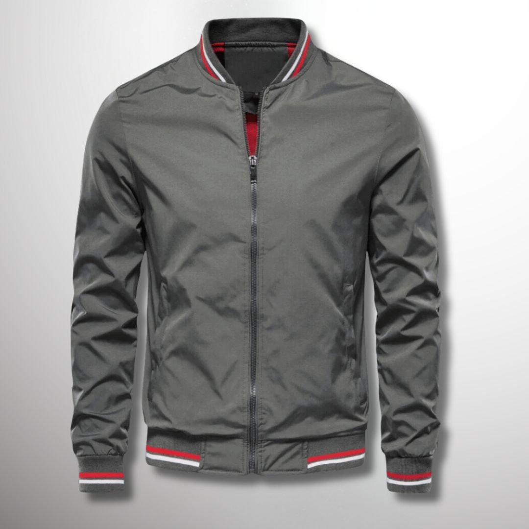 Giacca bomber grigia da uomo con zip, colletto e polsini a righe rosse e bianche. Moda casual, abbigliamento autunnale, stile urbano.