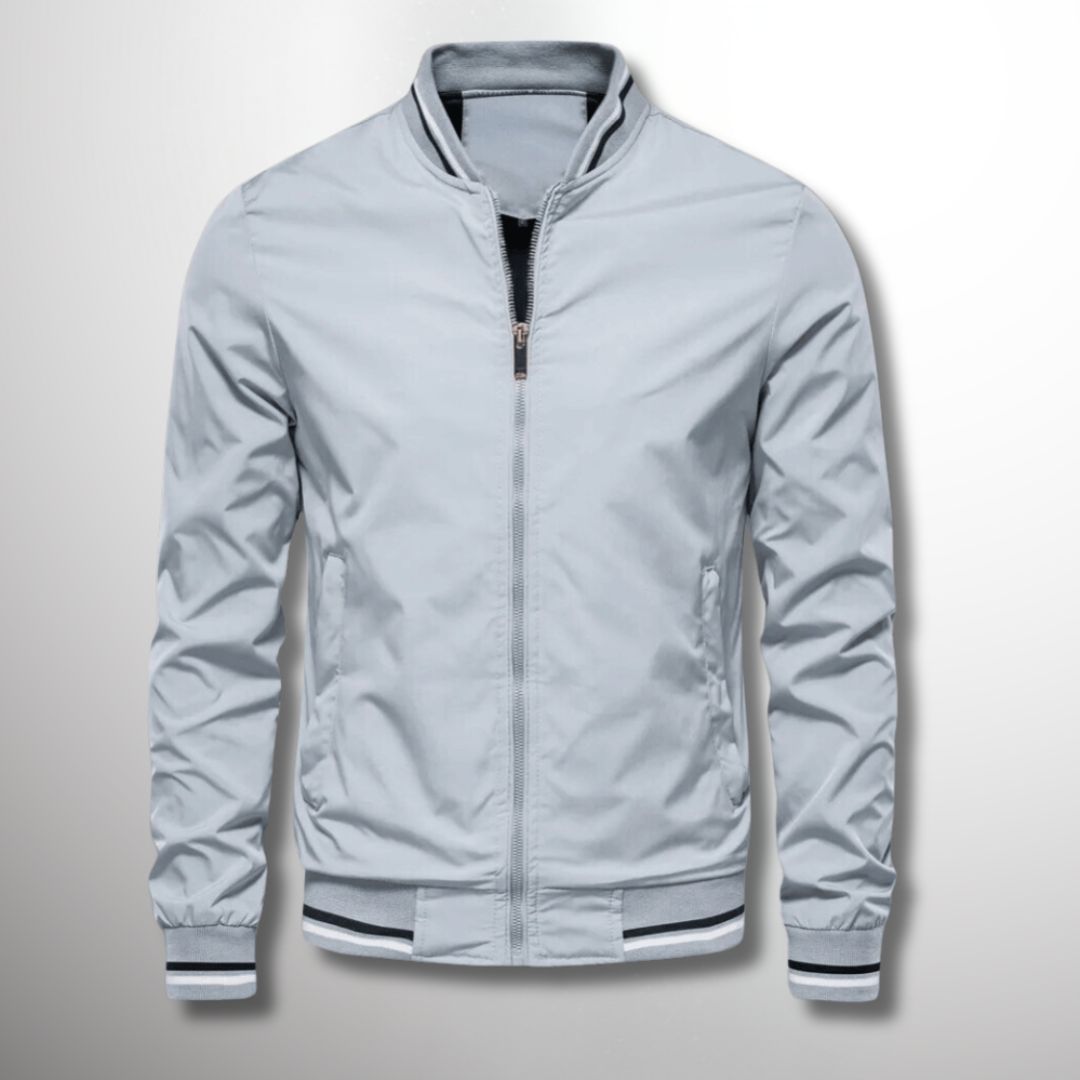 Giacca bomber grigia da uomo, stile casual, con zip frontale e polsini a righe. Perfetta per moda autunnale e look urbano.