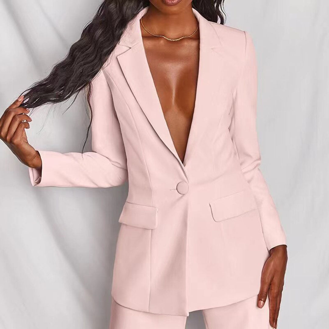 Donna in elegante blazer rosa chiaro, senza camicia, su sfondo bianco. Moda femminile, abbigliamento formale, stile sofisticato.