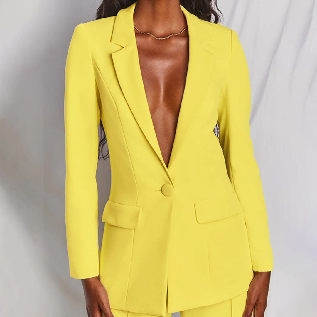 Giacca blazer gialla elegante, donna in posa su sfondo neutro. Moda femminile, abbigliamento formale, tendenza colore vivace.