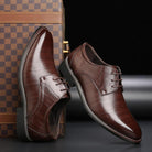 Scarpe eleganti da uomo in pelle marrone lucida, stile derby, su sfondo nero con valigia a scacchi. Calzature formali di lusso.