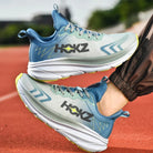 Scarpe da corsa HOKZ su pista atletica, design moderno blu e grigio, suola ammortizzata, ideali per jogging e sport all'aperto.