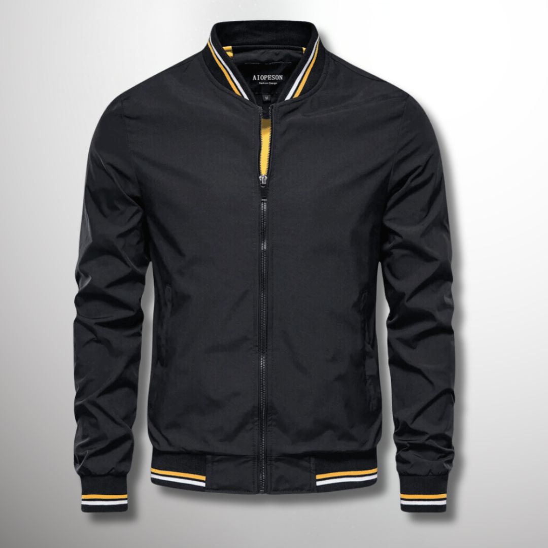 Giacca bomber nera da uomo con zip, dettagli gialli e bianchi, stile casual, moda autunno, tessuto leggero, colletto e polsini a righe.
