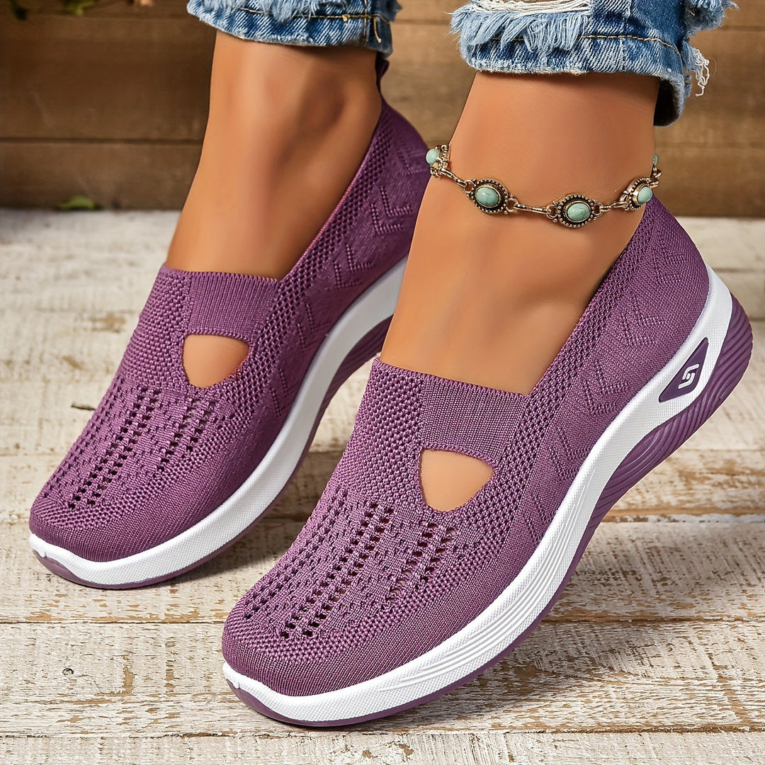 Scarpe da donna viola con zeppa, design traforato, suola bianca, indossate con jeans e cavigliera con perline turchesi. Scarpe comode e alla moda.