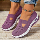 Scarpe da donna viola con zeppa, design traforato, suola bianca, indossate con jeans e cavigliera con perline turchesi. Scarpe comode e alla moda.
