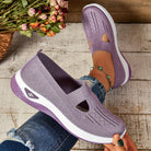 Scarpe da donna viola in maglia traspirante, suola bianca, indossate con jeans strappati. Design casual e comodo, perfetto per la moda estiva.