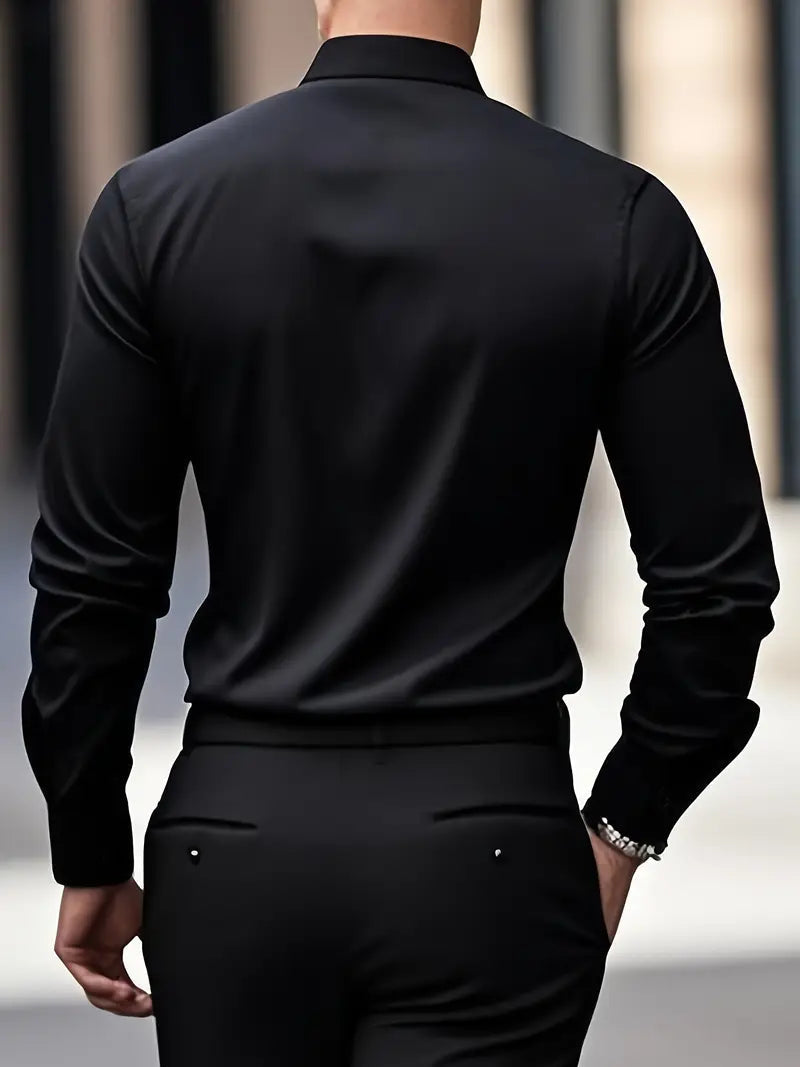 Uomo in camicia nera elegante, visto di spalle, cammina in ambiente urbano. Moda maschile, abbigliamento formale, stile contemporaneo.