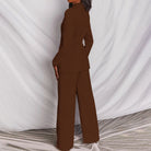 Completo donna marrone elegante, giacca e pantaloni larghi, su sfondo bianco. Moda femminile, abbigliamento formale, tendenze 2023.
