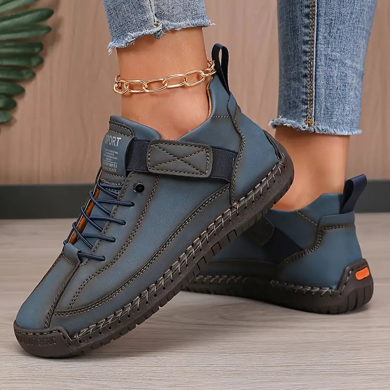 Scarpe sportive blu da donna, design moderno con suola robusta e lacci, indossate con jeans. Perfette per look casual e comfort quotidiano.
