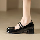 Scarpe nere lucide con tacco medio e doppio cinturino, eleganti e alla moda, ideali per abbigliamento formale o casual chic.
