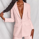 Donna in elegante blazer rosa chiaro, senza camicia, su sfondo bianco. Moda femminile, abbigliamento formale, stile sofisticato.