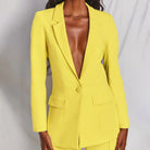 Giacca blazer gialla elegante, donna in posa su sfondo neutro. Moda femminile, abbigliamento formale, tendenza colore vivace.