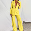 Donna in elegante completo pantalone giallo, giacca con scollo profondo, moda femminile, abbigliamento formale, tendenza abiti colorati.